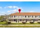 Exterior view of townhouses with a terra cotta roof, screened patios, and a central geolocation marker at 1149 S Beach Cir, Kissimmee, FL 34746