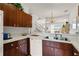 Functional kitchen with white counters and wood cabinets, offering a view to the dining and living spaces at 1149 S Beach Cir, Kissimmee, FL 34746