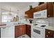 Well-lit kitchen featuring white appliances, wood cabinets, and a convenient microwave for easy cooking at 1149 S Beach Cir, Kissimmee, FL 34746