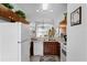 Cozy kitchen with white appliances and warm wood cabinetry offering a view into the living area at 1149 S Beach Cir, Kissimmee, FL 34746