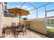 Covered patio with a glass table, four chairs, and views of the community at 1149 S Beach Cir, Kissimmee, FL 34746