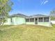 This backyard features green grass, a screened in back porch, and light green siding at 1167 Saint Tropez Ct, Kissimmee, FL 34759
