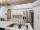 Open kitchen with stainless steel refrigerator, granite countertops, and tiled backsplash at 1167 Saint Tropez Ct, Kissimmee, FL 34759