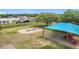 Aerial view of a shady playground with swings, slide, and covered play area at 1167 Saint Tropez Ct, Kissimmee, FL 34759