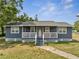 Charming single-story home featuring a lovely front porch with white railings and a well-maintained lawn at 1226 Pine St, Orlando, FL 32824