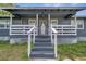 Inviting front porch with white railings, leading to the front door, enhanced by decorative lattice trim at 1226 Pine St, Orlando, FL 32824