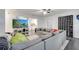 Open-concept living room featuring a cozy gray sectional sofa, view of the kitchen, and modern gray flooring at 1226 Pine St, Orlando, FL 32824