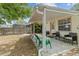 Covered patio with outdoor seating, complemented by a fenced backyard and lush greenery at 1345 Tindaro Dr, Apopka, FL 32703