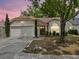 Charming single-story home at twilight featuring a two-car garage and arched window at 1345 Tindaro Dr, Apopka, FL 32703