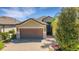 Charming home featuring a brown garage door, stone accents, and a beautiful brick driveway at 164 Montoro Ln, Davenport, FL 33837