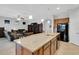 A kitchen island with granite countertop and bar stools with a view of the living room at 164 Montoro Ln, Davenport, FL 33837
