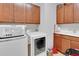 Well-organized laundry room with modern appliances and ample storage in wooden cabinets at 164 Montoro Ln, Davenport, FL 33837