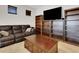 Comfortable living room featuring a plush couch, dark wood bookshelves, and a large coffee table at 164 Montoro Ln, Davenport, FL 33837