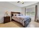 Main bedroom with a large window, side tables, a ceiling fan, and neutral walls at 164 Montoro Ln, Davenport, FL 33837