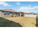 Backyard view of house, screened in patio, privacy fence, and well-maintained lawn at 1654 Chatsworth Cir, St Cloud, FL 34771