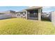 Backyard featuring a spacious lawn, privacy fence, and a screened-in patio at 1654 Chatsworth Cir, St Cloud, FL 34771