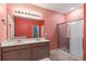 Bathroom featuring a double sink vanity, large mirror, glass shower enclosure, and a separate toilet area at 1654 Chatsworth Cir, St Cloud, FL 34771