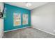 Bedroom features carpeted flooring, two large windows, and light gray walls with a blue accent wall at 1654 Chatsworth Cir, St Cloud, FL 34771