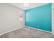 Bright bedroom featuring gray carpet, a window, and an accent wall painted in a bright teal color at 1654 Chatsworth Cir, St Cloud, FL 34771
