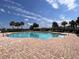 Beautiful community pool area with clear water, brick deck, and palm trees under a sunny sky at 1654 Chatsworth Cir, St Cloud, FL 34771