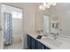 Bathroom with double sinks, white countertop, and a shower with a patterned curtain at 1923 Lazy Oaks Loop, St Cloud, FL 34771
