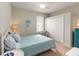 Cozy bedroom with blue quilt, ceiling fan, and natural light from the window at 1923 Lazy Oaks Loop, St Cloud, FL 34771