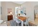 A dining room features a wooden table with white chairs and an adjacent living room at 1923 Lazy Oaks Loop, St Cloud, FL 34771