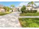 Inviting single-story home featuring a well-manicured lawn, swaying palm trees, and a spacious driveway leading to a grand entrance at 1923 Lazy Oaks Loop, St Cloud, FL 34771