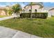 Lush front lawn with vibrant green hedges and decorative planting beds complements the home's exterior at 1923 Lazy Oaks Loop, St Cloud, FL 34771