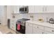 Modern kitchen with white cabinets, quartz countertops, and stainless steel appliances at 1923 Lazy Oaks Loop, St Cloud, FL 34771