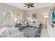 Cozy living room showcasing large arched windows, a ceiling fan, and comfortable seating arrangement at 1923 Lazy Oaks Loop, St Cloud, FL 34771