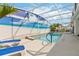 Screened-in pool area features a lounging area and a serene beach themed mural at 1923 Lazy Oaks Loop, St Cloud, FL 34771