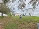 Sprawling backyard with green lawn, mature trees, and patio area offers a private outdoor retreat at 2015 Barstow Ln, Dundee, FL 33838