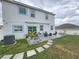 Large backyard features a stone patio, seating, lush greenery, and stepping stones, ideal for outdoor living at 2015 Barstow Ln, Dundee, FL 33838