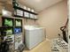Functional laundry room with washer, dryer, shelving, and organized storage solutions at 2015 Barstow Ln, Dundee, FL 33838