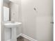This half-bathroom features a pedestal sink, wood look floors, and a minimalist design at 2017 Camden Loop, Davenport, FL 33837