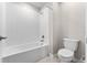 Bright bathroom with a white tiled shower and tub combo and toilet at 2017 Camden Loop, Davenport, FL 33837