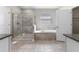 A spacious bathroom with a glass-enclosed shower and a luxurious soaking tub at 2017 Camden Loop, Davenport, FL 33837