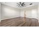 A bright bedroom features dark wood floors, a ceiling fan, and neutral walls at 2017 Camden Loop, Davenport, FL 33837
