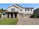 Charming two-story home with a well-manicured lawn and a three-car garage on a brick driveway at 2017 Camden Loop, Davenport, FL 33837
