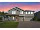 Charming two-story home with a well-manicured lawn and a three-car garage during a colorful sunset at 2017 Camden Loop, Davenport, FL 33837
