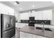 Modern kitchen featuring stainless steel appliances, a large island, stone accents, and dark backsplash at 2017 Camden Loop, Davenport, FL 33837