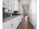 Long shot of kitchen featuring granite counters, stainless steel appliances, grey tile backsplash and wooden floors at 2017 Camden Loop, Davenport, FL 33837