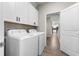 Functional laundry room featuring washer, dryer, and overhead cabinets at 2017 Camden Loop, Davenport, FL 33837
