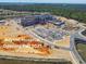 Advent Hospital construction site with parking and roads surrounded by lush greenery, set to open Fall 2025 at 2238 Gold Dust Dr, Clermont, FL 34715