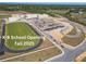K-8 School construction site with parking and roads, surrounded by green athletic fields and lush greenery, opening Fall 2025 at 2238 Gold Dust Dr, Clermont, FL 34715