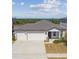 Inviting home featuring a three-car garage, covered porch, and manicured landscaping at 2238 Gold Dust Dr, Clermont, FL 34715