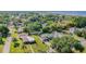 Wide aerial view of neighborhood, lush trees surrounding a quaint house with attached carport at 224 Pennsylvania Ave, St Cloud, FL 34769