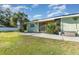 Backyard with a concrete patio, lush green lawn, trees and utility shed at 224 Pennsylvania Ave, St Cloud, FL 34769