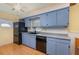 Kitchen with black appliances, blue cabinets, and hardwood floors at 224 Pennsylvania Ave, St Cloud, FL 34769